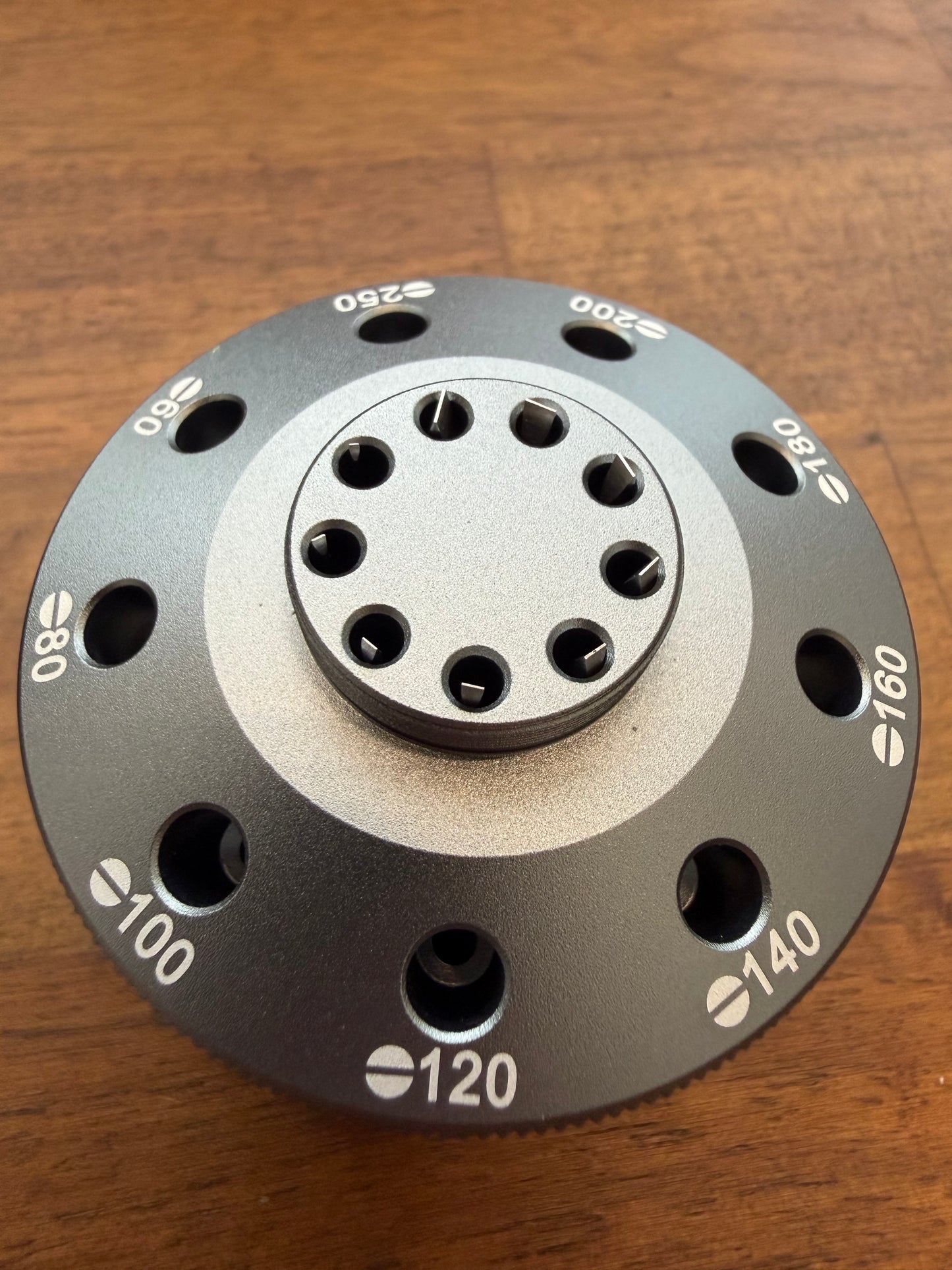 Metallic disc with measurement markings on a wooden surface