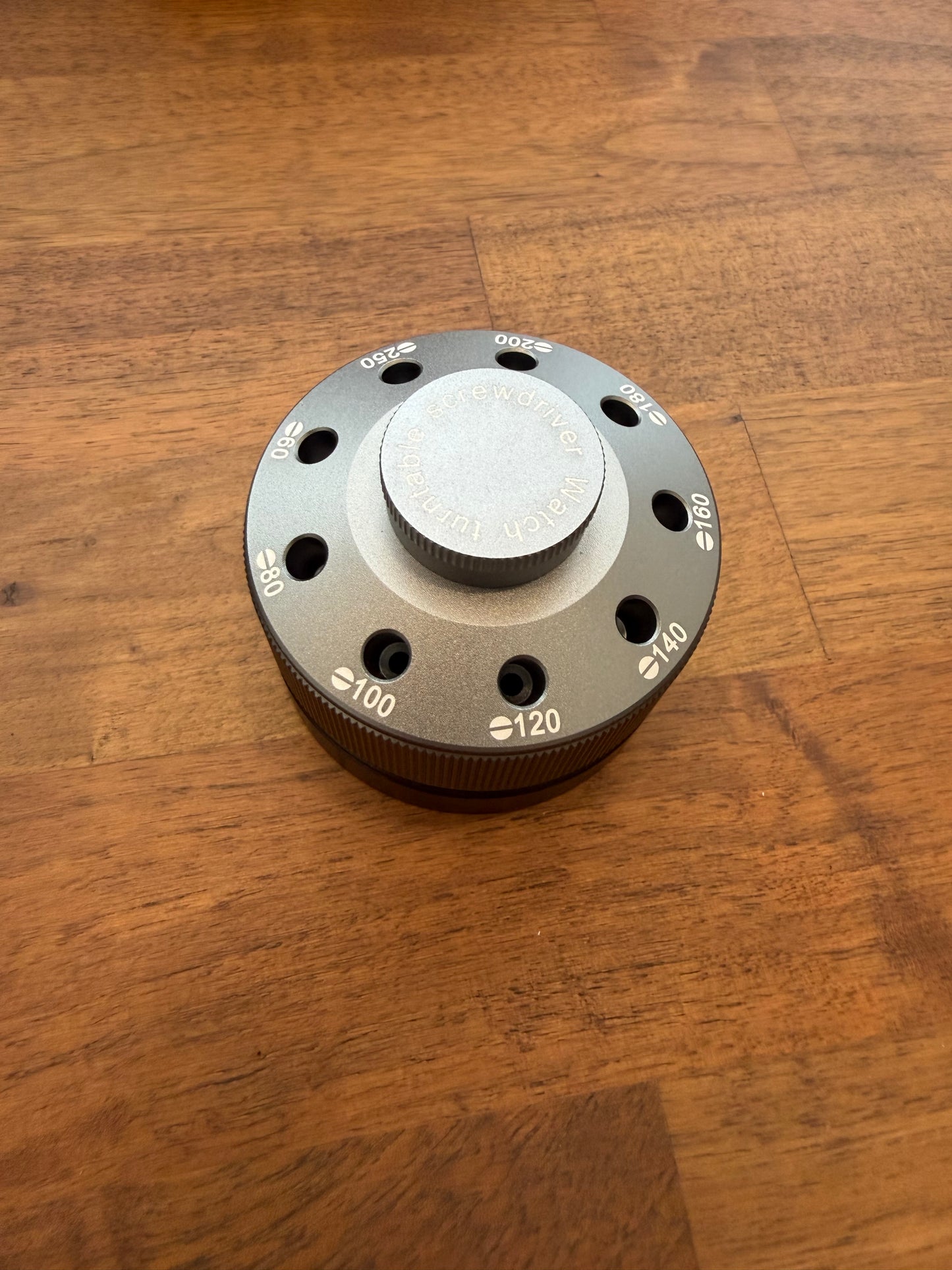 Metallic knob with numerical markings on a wooden surface