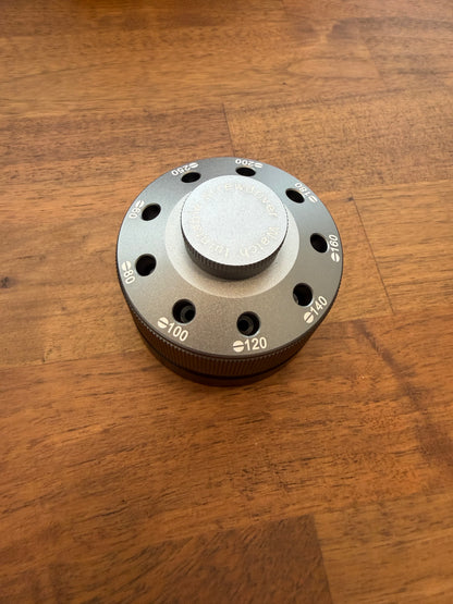 Metallic knob with numerical markings on a wooden surface