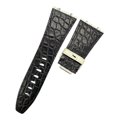Black crocodile-patterned watch strap with beige buckle on a white background